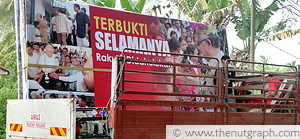 Workers setting up a BN feel-good billboard in Kampung Tiong, Sungai Terah